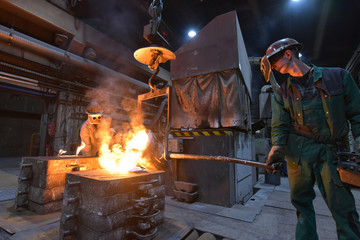 workers in a foundry - hot workplace for the production of steel castings  // Giessereiarbeiter in...