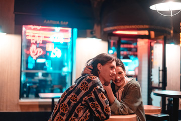 Young couple at the bar, street of the night city