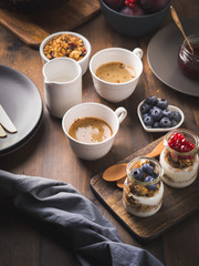 Cozy Breakfast concept on dark wooden textured background. Coffee and yogurt with home made granola