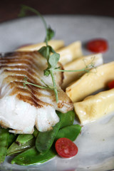 Fillet of cod with dumplings, carrots, green sweet pea and tomatoes
