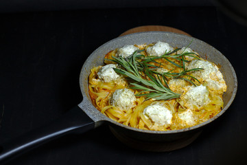 spaghetti nests with chicken meatballs and sour cream sauce on dark table