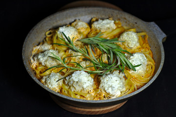 spaghetti nests with chicken meatballs and sour cream sauce on dark table