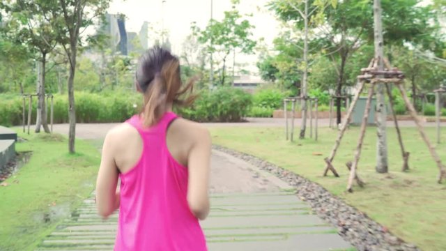 Healthy beautiful young Asian runner woman in sports clothing running and jogging on street in urban city park. Lifestyle fit and active women exercise in the city concept.
