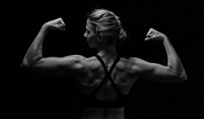 Fototapeta na wymiar Fit woman with shaped muscles on back in artistic conversion