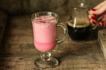 latte beetroot (beet juice) - pink coffee with milk in a transparent cup on the table. top view.