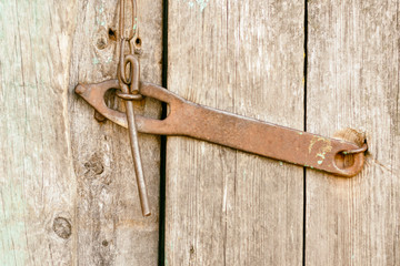 Old antique iron lock, deadbolt, bolt on the door is not painted close-up.