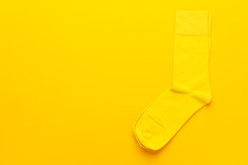 pair of socks on bright yellow background. top view of yellow socks with copy space