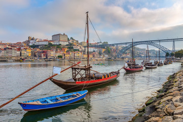 Naklejka na ściany i meble Traditional boats with barrels of wine, on the Douro River in the Portuguese city of Porto.