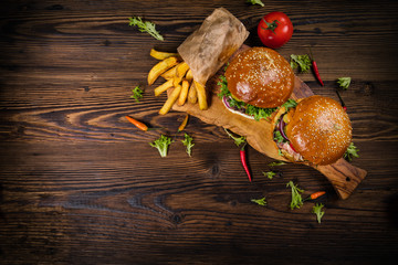 Delicious hamburgers with fries, served on wood