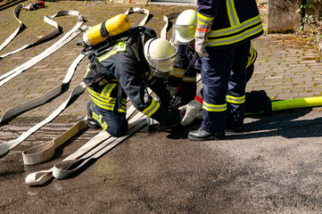Feuerwehrmänner beim anschließen einer Schlauchleitung