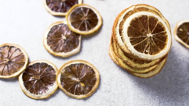 Dried orange rotating on white tecture surface. Close up.