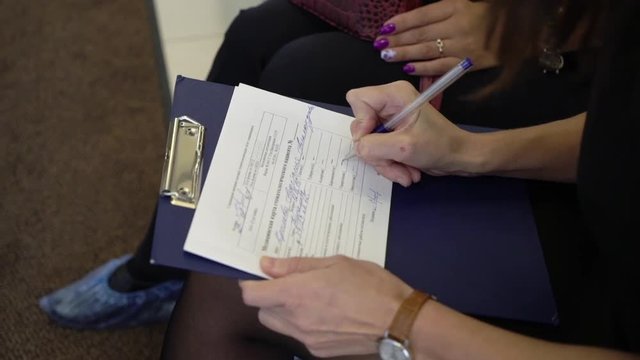Female patient is signing some documents in an medical office or clinic