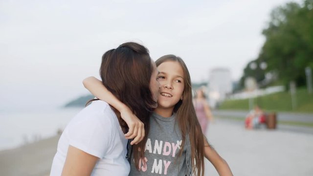 10 year old girl on a scooter pulls up to her mother and kisses her. 4k
