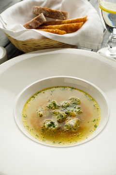 Soup broth with meatballs in a white plate. Concept for a menu in a restaurant