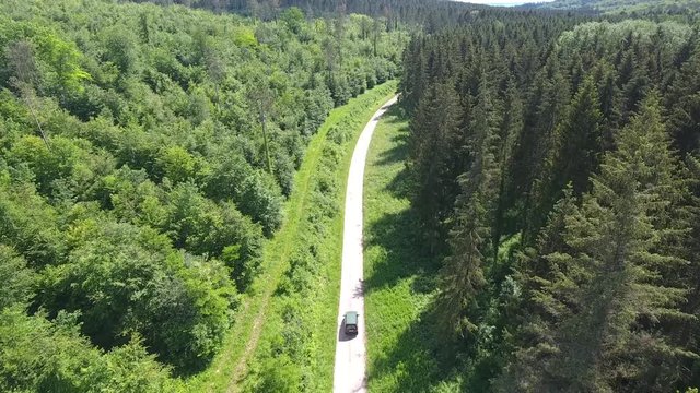 Drone shot following a forestry worker car on a path in Verdun forest. France