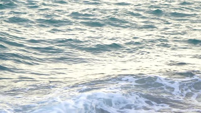 Beautiful natural marine background. Sunny blue calm sea water surface shoot at sunset time on sandy beach. Turkey. Real time 4k video footage.