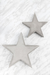 Two concrete stars on marble background