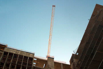 The boom of a construction crane on blue sky background.