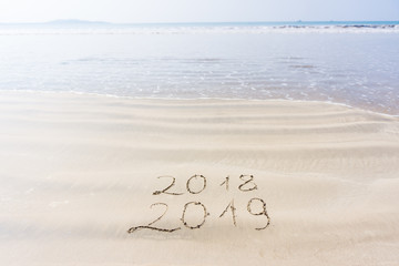 The inscription on the sand 2018 2019 against the background of sea and sky