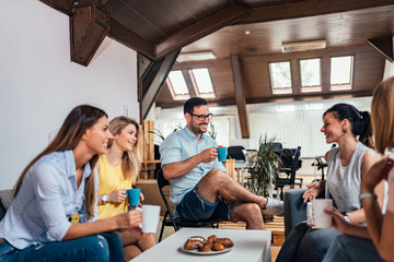 Cheerful coworkers having coffee break.