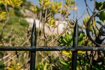 Vintage key is hangingon iron fence in the southern city