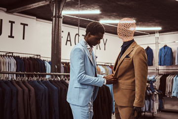 Elegantly dressed African-American man working at classic menswear store.