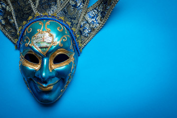 A blue Mardi Gras or carnival jester mask on a blue background