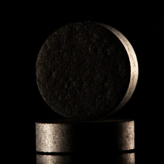 Medical drug, black tablet Activated carbon on a black background in backlight