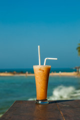 tropical fresh Fruit juice on the background of the sea vertical