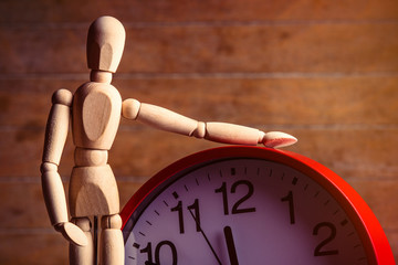 photo of the beautiful gestalta with red alarm clock on the brown wooden background