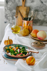 Fototapeta na wymiar Salad with baked pumpkin, apple, broccoli and pine nuts. Ceramic plates handmade. Rustic style.