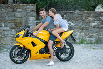 Fototapeta na wymiar Young couple on a motor bike on a late summer afternoon