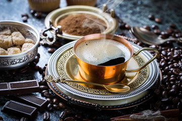 Black coffee in a cup on old background