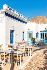 Chairs and tables in typical Greek cafe on street in Chora of Serifos. Cyclades, Greece