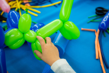 Boy's hands with balloon animal toy on twisting art workshop