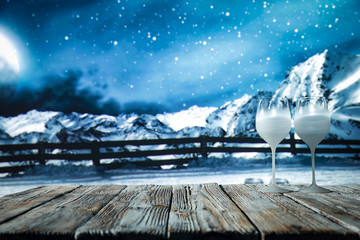 Glass wine glasses on a wooden board in a beautiful winter environment   