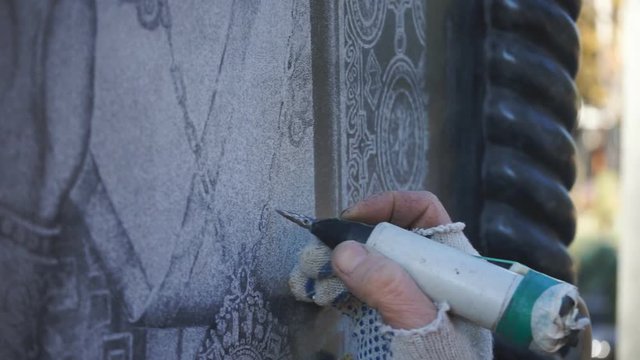The master manually engraves the icon on the stone