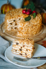 autumn cake decorated with paradise apples. Autumn still life with cake. Traditional Russian honey cake. Honey cake with sour cream, prunes and walnuts.