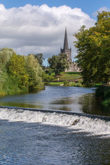 Church along a river in Ireland with waterfall in foreground