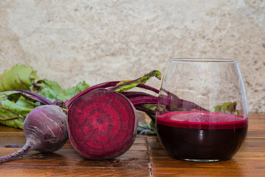 Vaso con jugo de remolacha y los vegetales sobre la mesa
