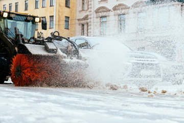 Snowplow truck vehicle removing snow after blizzard and snowstorm in motion, cropped image. Urgent city street cleaning at daylight. Snowfall at European city. Winter in St. Petersburg