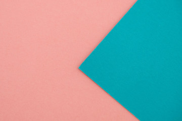 Turquoise paper on the background of pink paper.