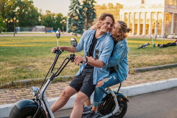Obraz premium Lovely young couple driving electric bike during summer. Modern city dating and transportation