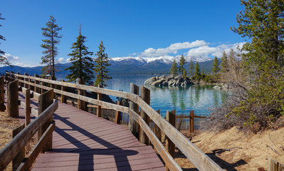 Romantic wooden walkway running along the sandy shore of beautiful Tahoe Lake.