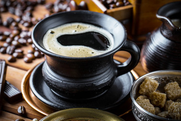 Black coffee in a cup on old background