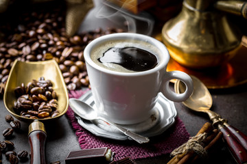 Black coffee in a cup on old background