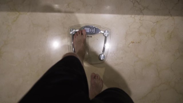 Skinny boy steps onto weighing scale, POV