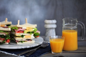 Fresh tasty sandwich with lettuce, ham, cheese, avocado, and tomato. English breakfast