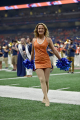 Young college cheerleader performing at a college football game