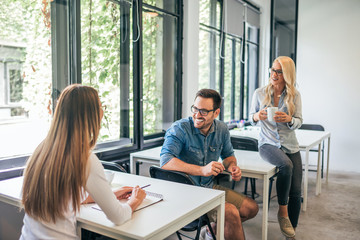 Talking while working in co working space. Three people talking on training class.